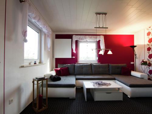 ゲスヴァインシュタインにあるVery bright friendly apartment with large roof terraceの赤い壁のリビングルーム(ソファ付)