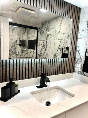 a bathroom with a sink and a large mirror at Theo's Oceanfront Breeze in Myrtle Beach