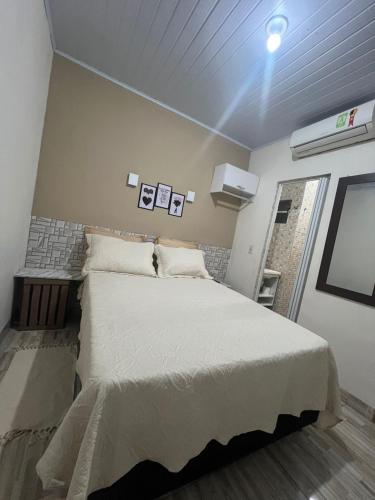 a bedroom with a large bed in a room at Pertinho do Aeroporto Hospedagem Particular in Várzea Grande