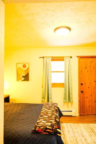 a bedroom with a bed and a window at Elevated Ski Chalet at Powderhorn Mountain in Bessemer