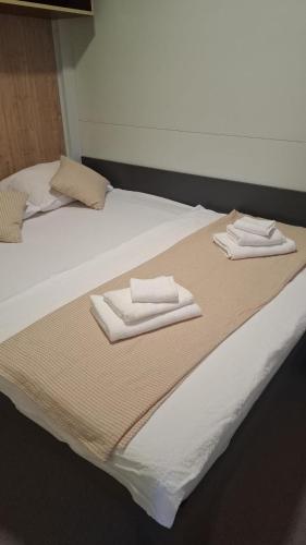 a bed with two folded towels on top of it at MobileHome Serdar in Sveti Filip i Jakov