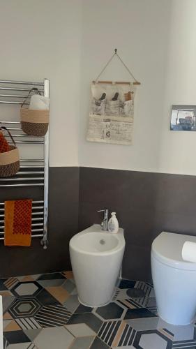 a bathroom with a white toilet and a sink at Maison Grimoaldo10 in Salerno