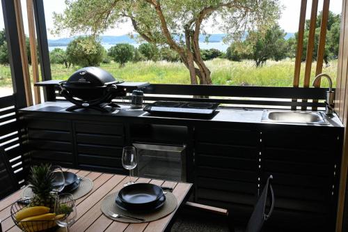 a kitchen with a counter and a sink and a table at MobileHome Serdar in Sveti Filip i Jakov