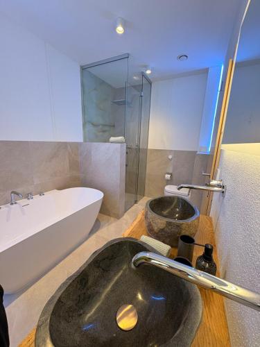 a bathroom with a sink and a bath tub at Alpenchalet Wasserfallblick in Ramsau