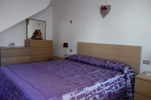 a bedroom with a purple bed with a purple comforter at Fabbricato Indipendente Centro in Lozzo Cadore