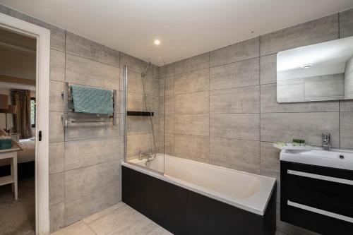 a bathroom with a bath tub and a sink at Gildridge in Lewes
