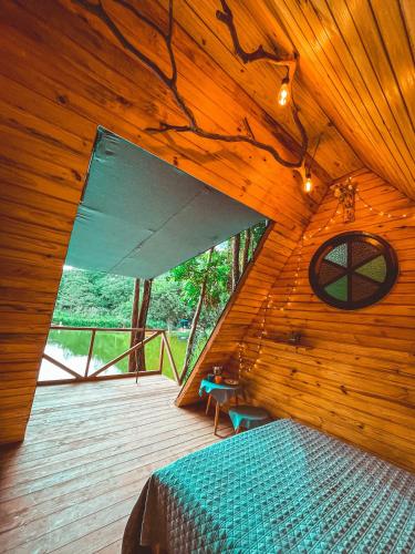 a room with a bed in a wooden cabin at Cabana nas árvores in Mairiporã