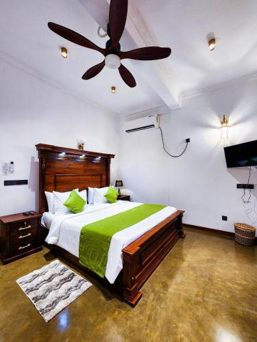 a bedroom with a bed and a ceiling fan at Ever Breeze Villa Ahangama in Ahangama