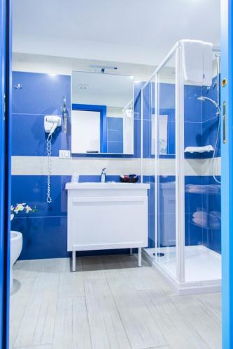 a blue bathroom with a sink and a shower at Hotel Centro Congressi Polo Nautico in Salerno