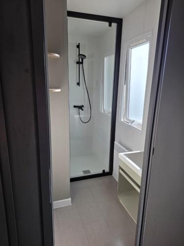 a bathroom with a shower and a sink and a mirror at Mobile Home Simplicity - Camp Diekirch in Gilsdorf