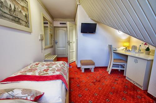 a room with two beds and a desk in a room at Hotel Toporów in Białka Tatrzanska