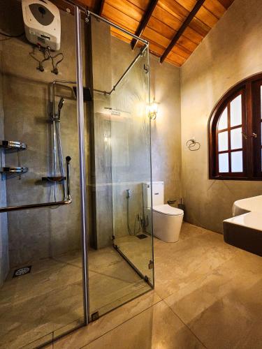 a bathroom with a glass shower and a toilet at Ever Breeze Villa Ahangama in Ahangama