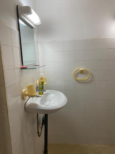 une salle de bains avec un lavabo blanc et un miroir dans l'établissement Chez Mathilde, à Cap Skirring