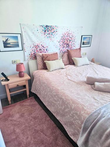 a bedroom with a large bed with a pink blanket at Digital Nomad Apartment in L'Escala