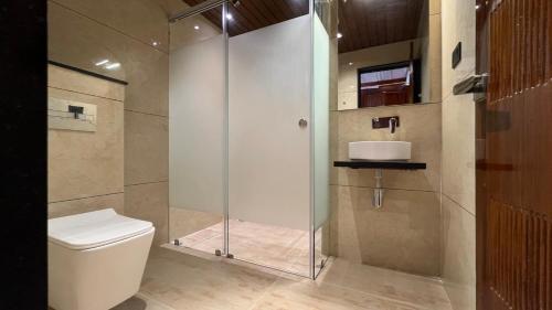 a bathroom with a shower stall and a toilet at Hotel Sudha Brahma in Tirupati