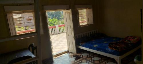 a small bedroom with a bed and two windows at Lucky Homes in Srīvardhan