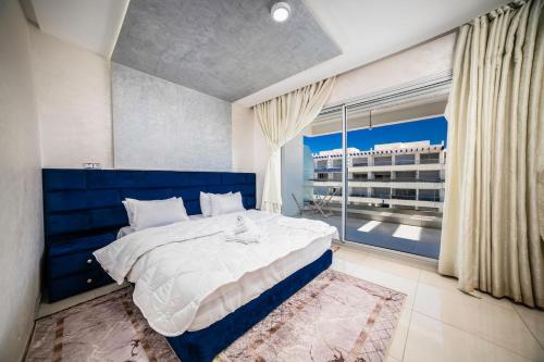 a bedroom with a large bed and a large window at Apartment in Adan Beach Residence With Pool in Aourir