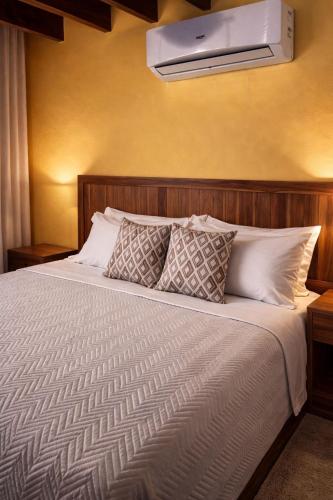 a bedroom with a large bed with a air conditioner on the wall at Caribbean Hill Villas in Cocles