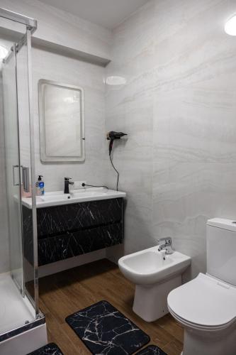 a white bathroom with a sink and a toilet at Family Airport in Chişinău