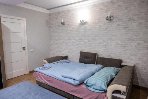 a bed in a room next to a brick wall at Family Airport in Chişinău