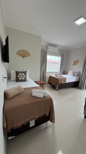 a bedroom with two beds and a large window at Pousada Vista Encantada Preá in Cruz