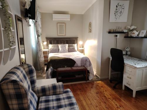 a bedroom with a bed and a desk and chairs at The Urban Oasis 4 guests Port Elizabeth Gqeberha in Gqeberha