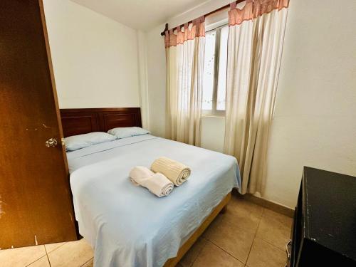 a bedroom with a bed with two towels on it at Casita Iluminada in Oaxaca City