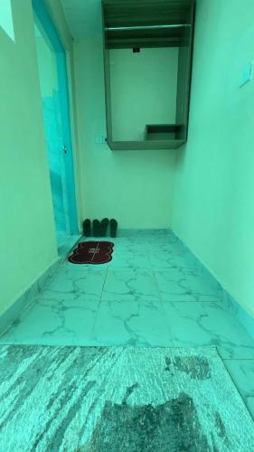 a bathroom with a mirror and a tile floor at EasyNest in Kinoo
