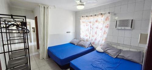 a small room with two beds and a window at STO01 - Casa ampla em bairro tranquilo do Guarujá in Guarujá