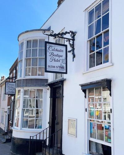 a white building with a sign for a shop at Colchester Boutique Hotel in Colchester
