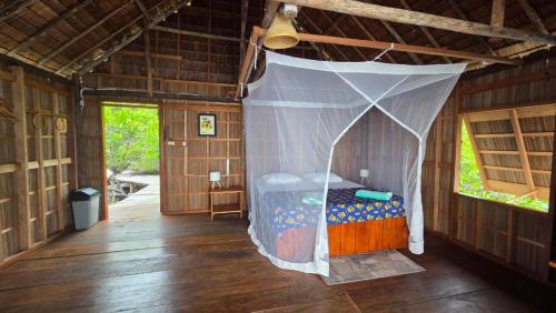 a bedroom with a canopy bed in a house at Yonas Homestay - Raja Ampat in Besir