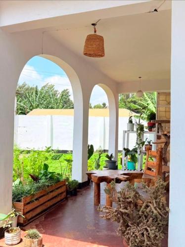 a patio with a table and some plants at Nguruma house of travellers and tours in Arusha