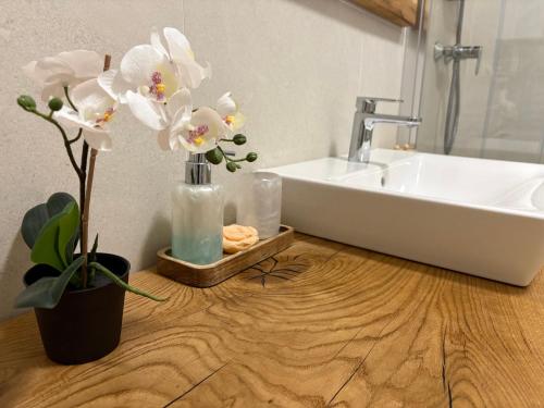 a bathroom with a sink and a vase with flowers at Apartman SPORKA in Púchov
