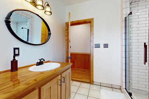 a bathroom with a sink and a mirror at Hot Tub + Dock! Waterfront Norris Lake Log Home in Elm Springs