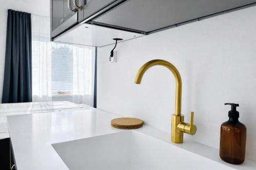 a kitchen with a sink and a gold faucet at Katariina Apartments in Kotka