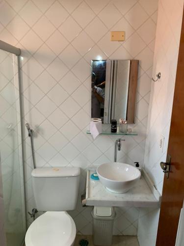 a bathroom with a white toilet and a sink at Chalé Gravatá 2022 in Gravatá