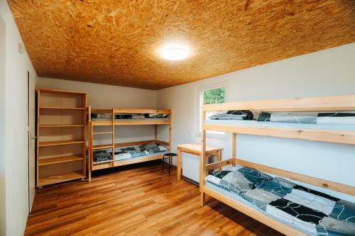 a room with bunk beds and wooden floors at Růžená - chatky u rybníka in Milevsko