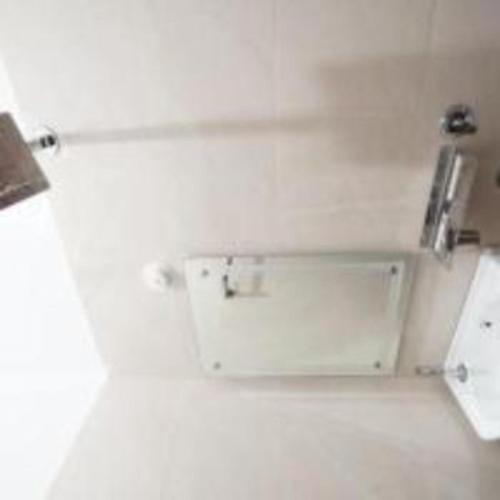 a bathroom with a white wall with a sink at Jai Shree Ram hotel in Ayodhya