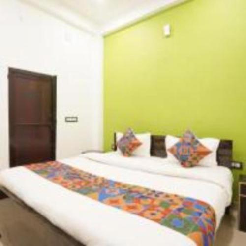 a bedroom with a large bed with green walls at Jai Shree Ram hotel in Ayodhya