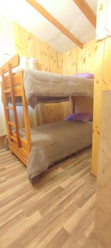 two bunk beds in a room with a wooden floor at Cabaña irenio in Panguipulli