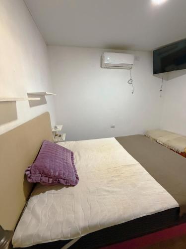 a small room with a bed with a purple pillow at ParaisolaRinconada in La Porteña