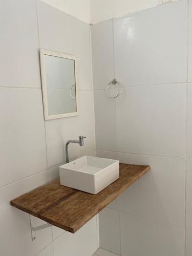 a bathroom with a white sink and a mirror at Casa Moreré in Ilha de Boipeba
