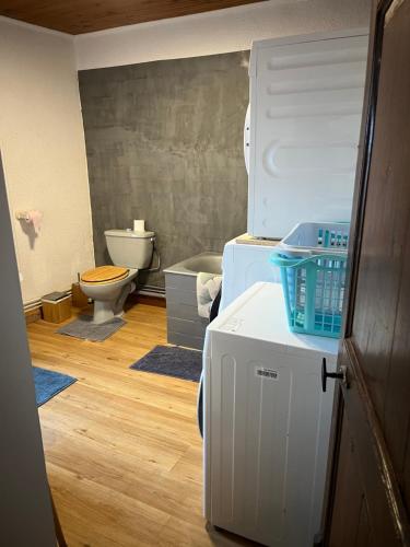a bathroom with a refrigerator and a toilet at Lou Castel in Le Clapier
