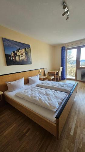 a bedroom with a large bed and a table at Huberwirt am Kellerberg in Wasserburg am Inn