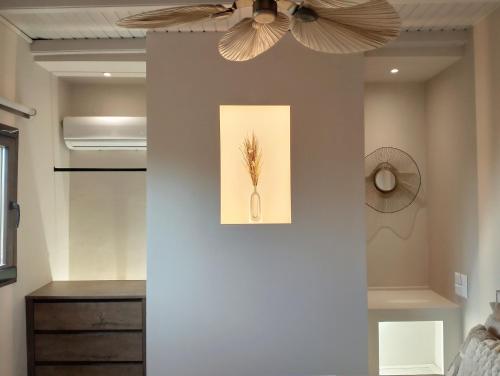 Ein Deckenventilator in einem Schlafzimmer mit einer Blume an der Wand in der Unterkunft maison jamouri in Kríni