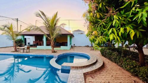 a swimming pool in front of a house at WELCOME LODGE in Ouagadougou
