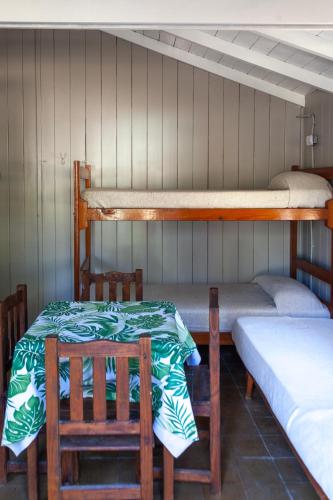 a room with three bunk beds and a table and chairs at Bungalow Caravan in Villa Gesell