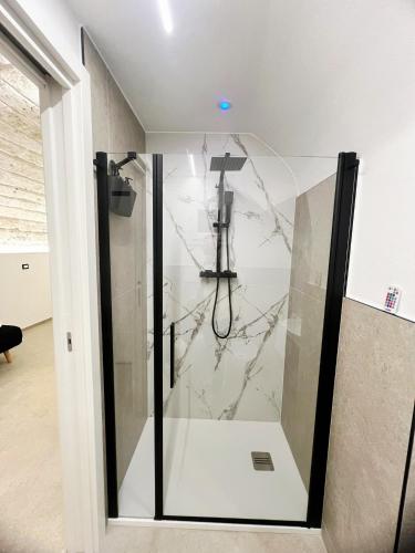 a shower with a glass door in a bathroom at Buonaventura house in Triggiano
