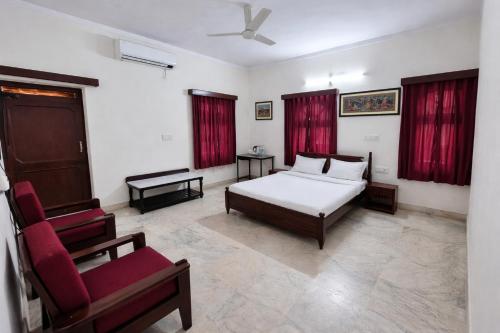 a bedroom with a bed and a chair at Hotel Gajender Niwas Sun City A Boutique Stay in Jodhpur