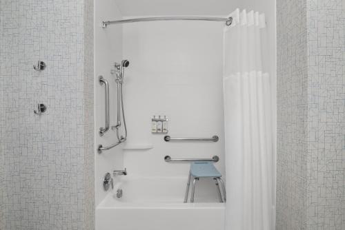 a bathroom with a shower with a blue stool in it at Holiday Inn Express Melbourne West by IHG in Melbourne